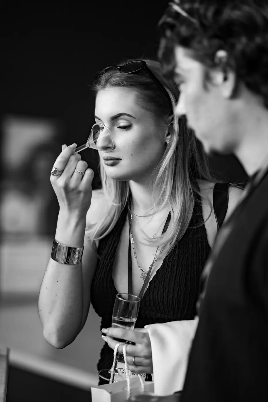 Une invitée respire une fragrance créée au bar à parfum — photographie noir et blanc